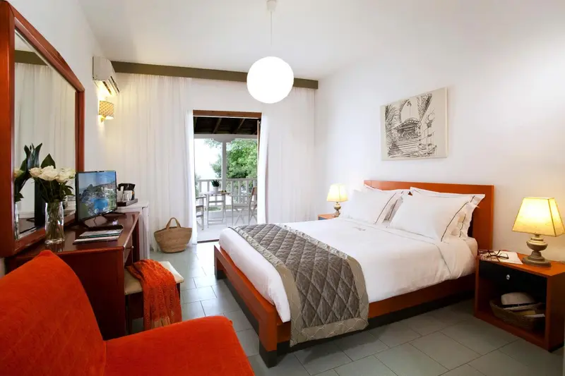 Une chambre lumineuse avec un lit double et un accès à une terrasse.