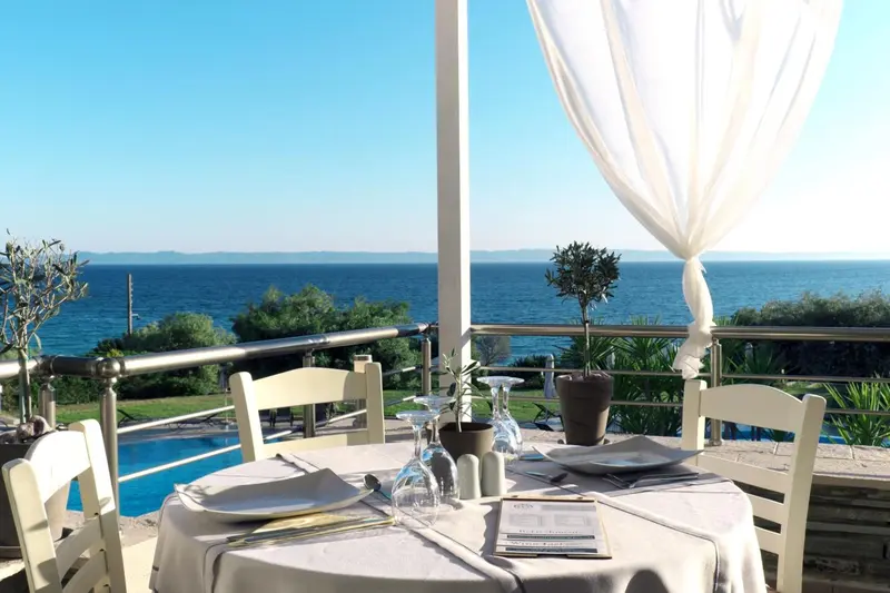 Table dressée sur une terrasse avec vue sur la mer.
