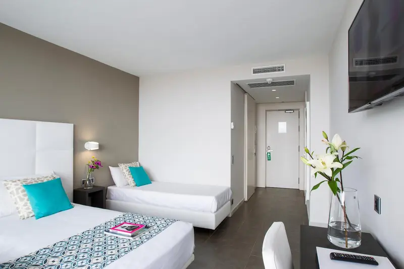 Une chambre lumineuse avec deux lits simples et une décoration moderne.
