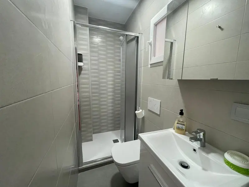 Une salle de bain moderne avec douche à l'italienne et vasque.