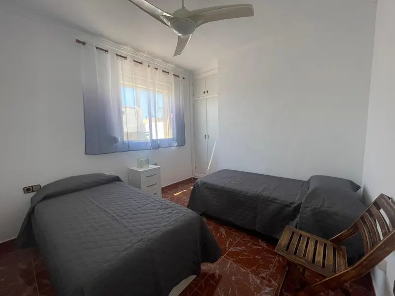 Une chambre avec deux lits simples et une fenêtre.