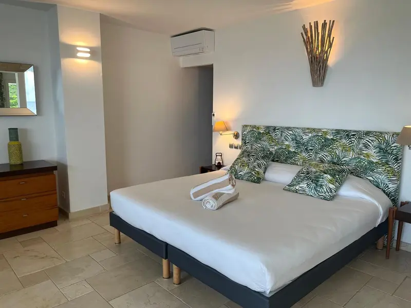 Une chambre lumineuse avec un grand lit recouvert de draps blancs.