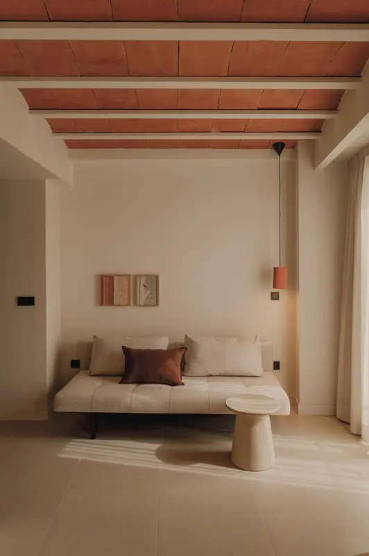 Un canapé beige et des coussins dans une pièce lumineuse.