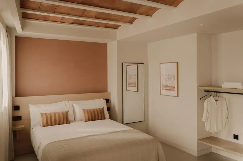 Une chambre à coucher lumineuse avec un lit double et des œuvres d'art au mur.