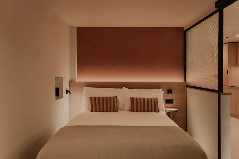 Une chambre avec un grand lit recouvert d'une couverture et de coussins.