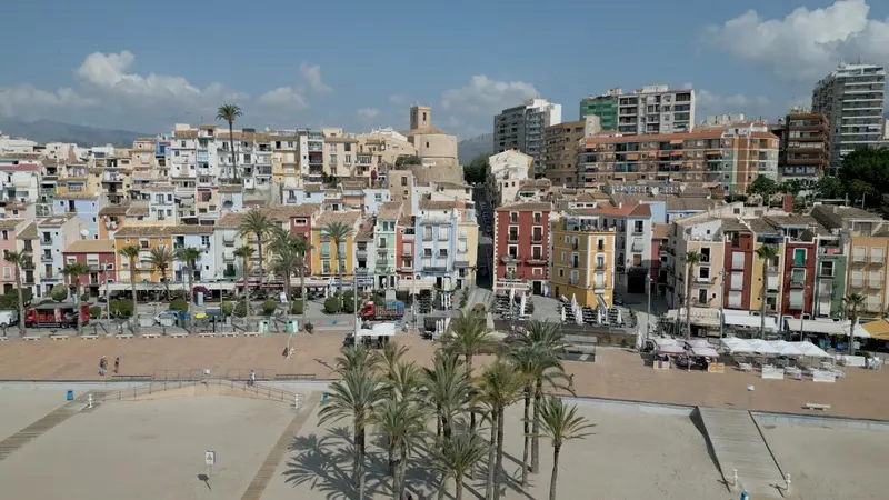Vue aérienne d'une ville côtière avec une plage et des palmiers.