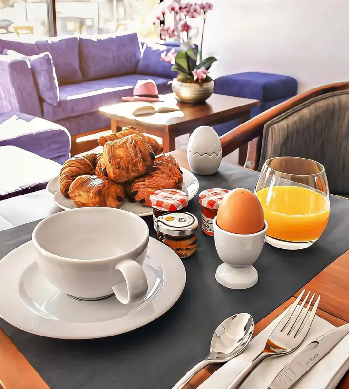 Un petit-déjeuner est servi sur une table basse devant un canapé.