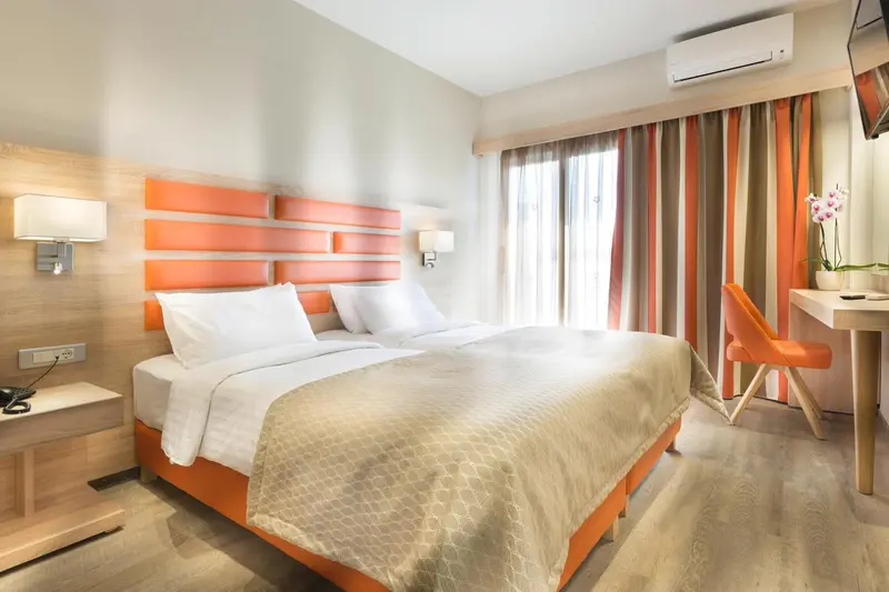 Une chambre lumineuse avec un grand lit et un bureau.