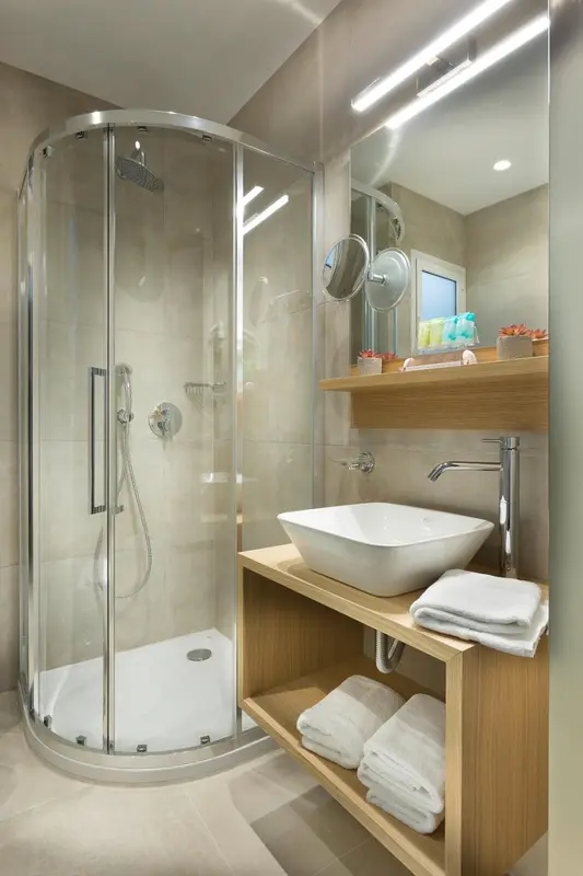 Une salle de bain moderne avec une douche à l'italienne et un lavabo sur un meuble en bois.