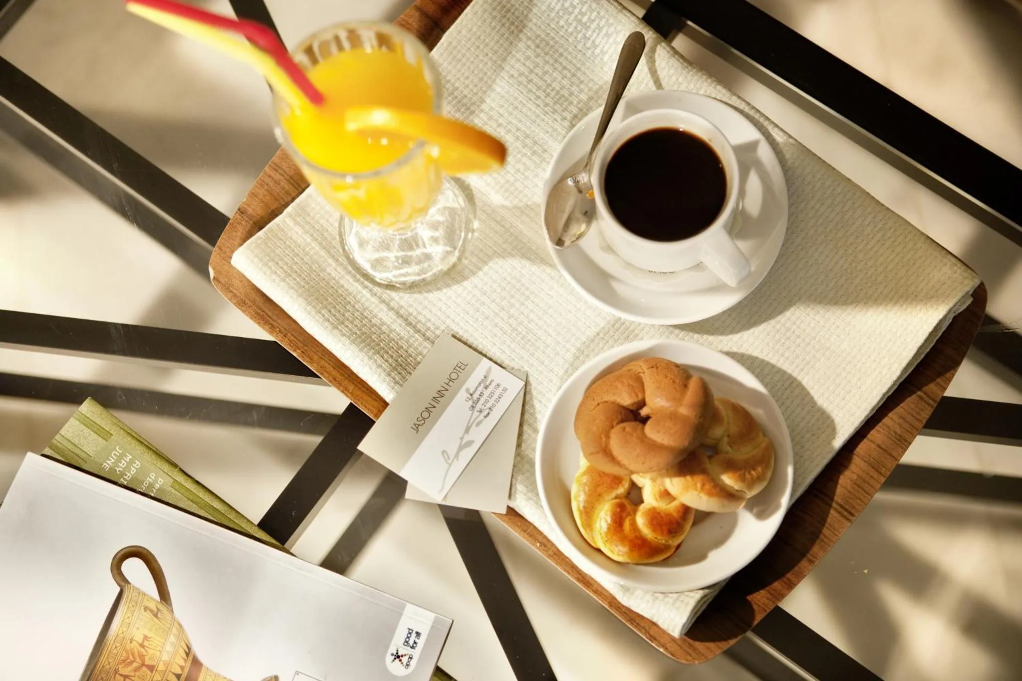 Un plateau de petit-déjeuner avec des viennoiseries, des boissons et une brochure.
