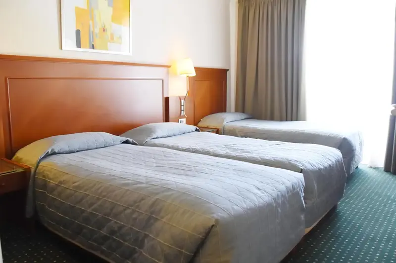 Une chambre avec deux lits simples et une décoration sobre.