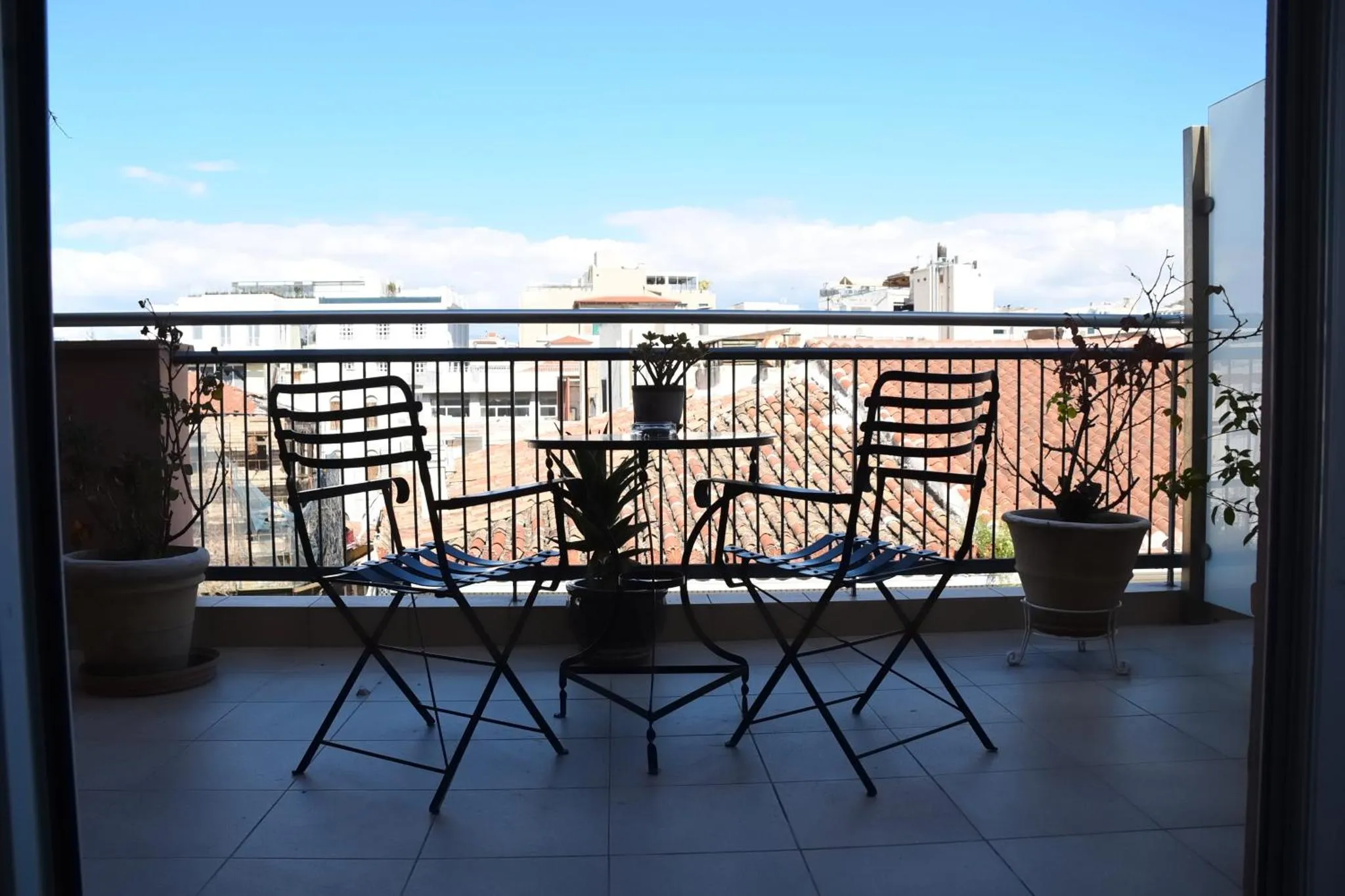 Terrasse avec mobilier de jardin et vue sur la ville.