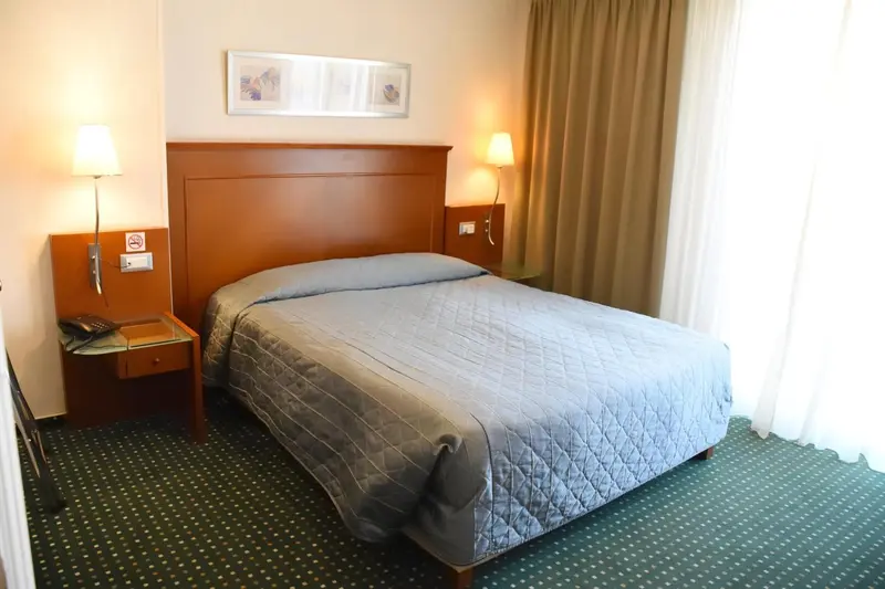 Une chambre d'hôtel avec un grand lit recouvert d'une couverture.