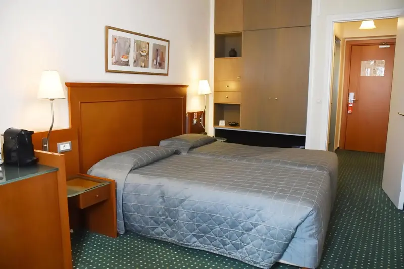 Une chambre d'hôtel avec un lit et un meuble de rangement.