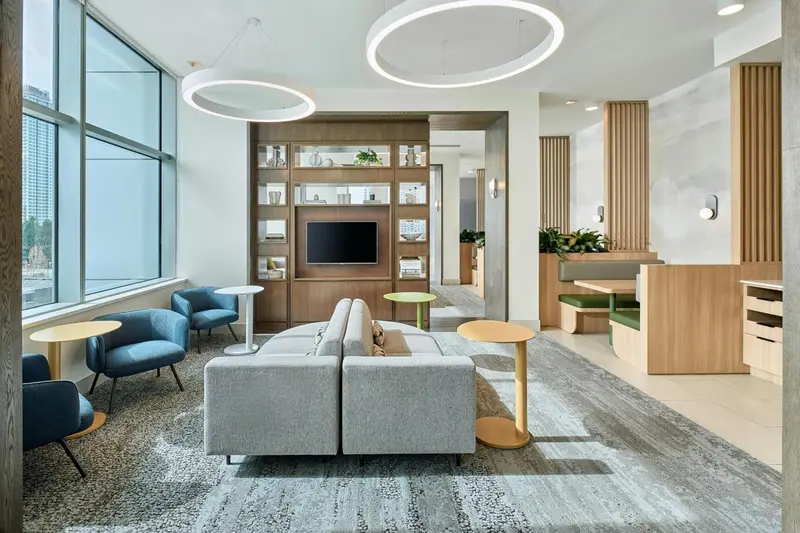 Un espace de détente intérieur avec canapés, fauteuils et une bibliothèque.