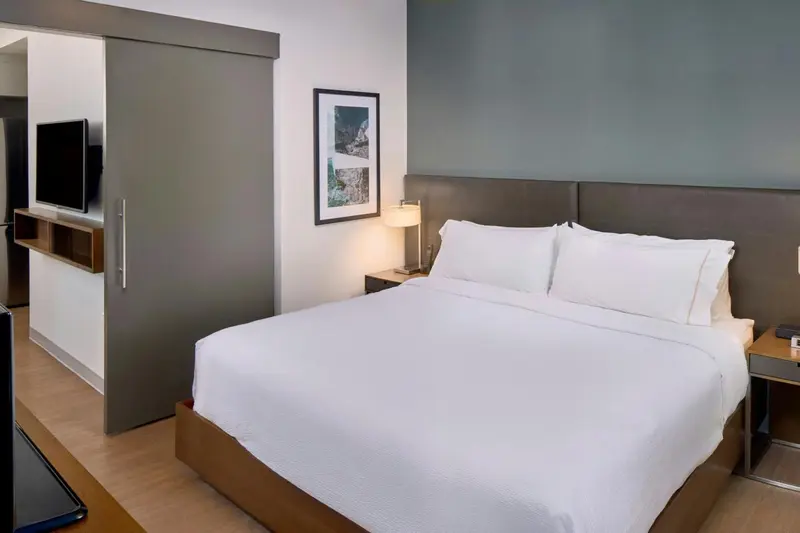 Une chambre lumineuse avec un grand lit recouvert de draps blancs.