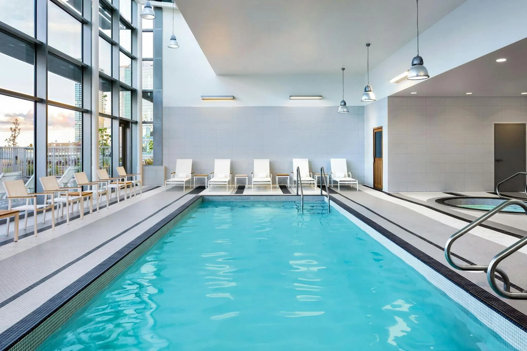 Une piscine intérieure avec des transats alignés le long du bassin.