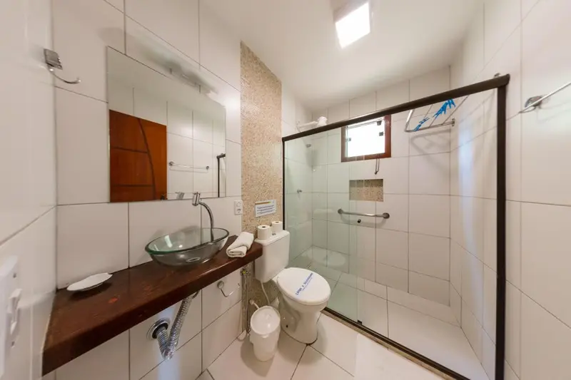 Une salle de bain claire avec douche et lavabo.