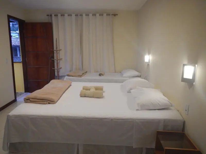 Une chambre lumineuse avec deux lits simples et une table de chevet.