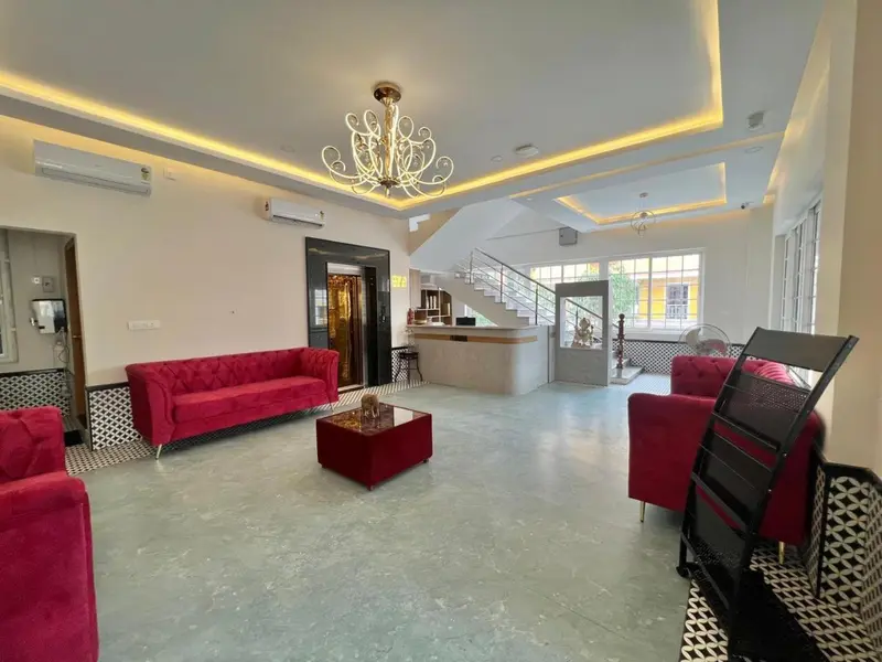 Espace de détente intérieur avec canapés rouges et éclairage moderne.