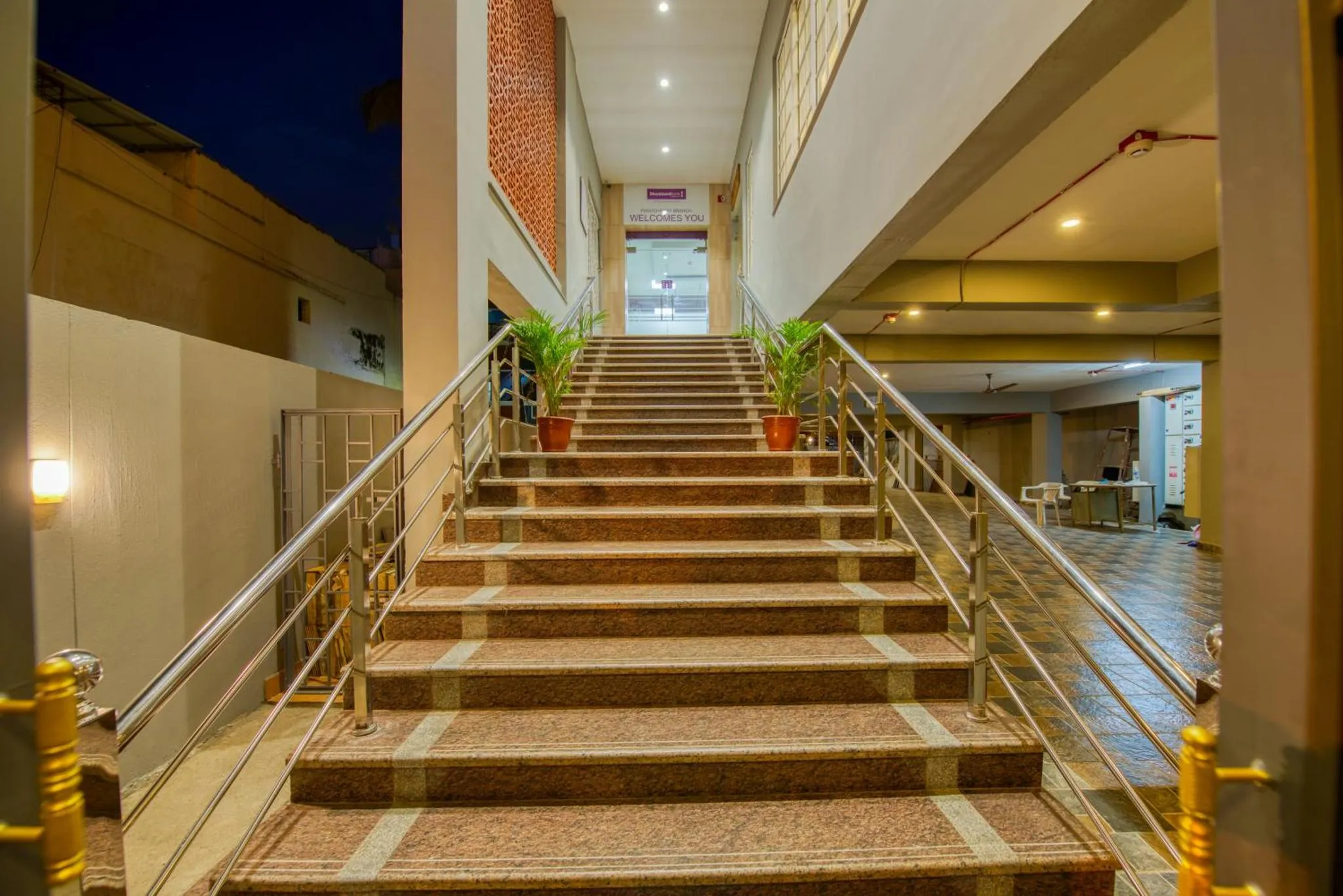 Un escalier mène à l'entrée d'un bâtiment éclairé.