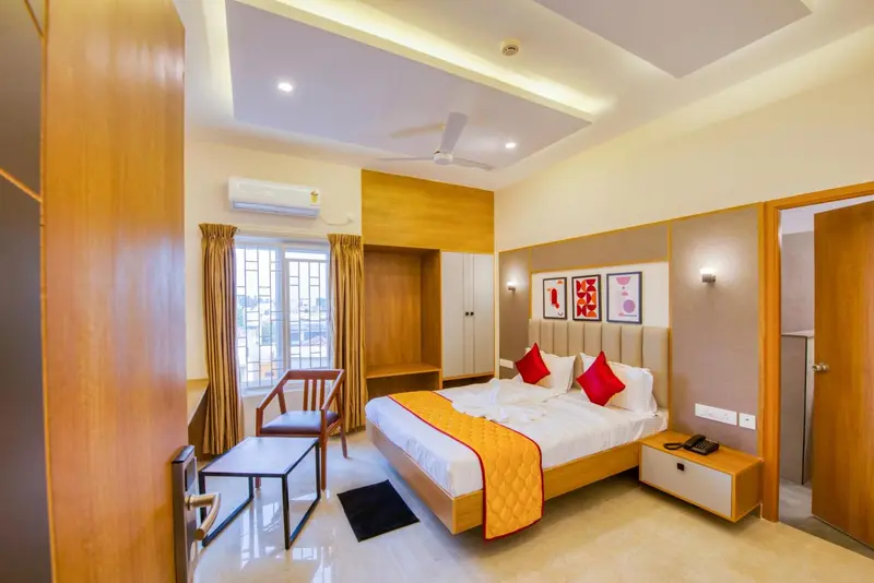 Une chambre lumineuse avec un grand lit et un coin salon.
