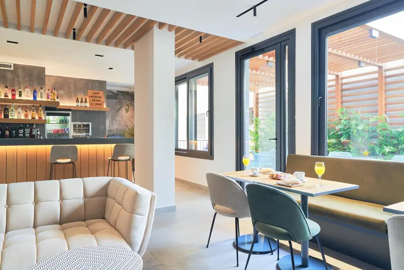 Un espace lumineux avec un bar et des tables pour le petit-déjeuner.