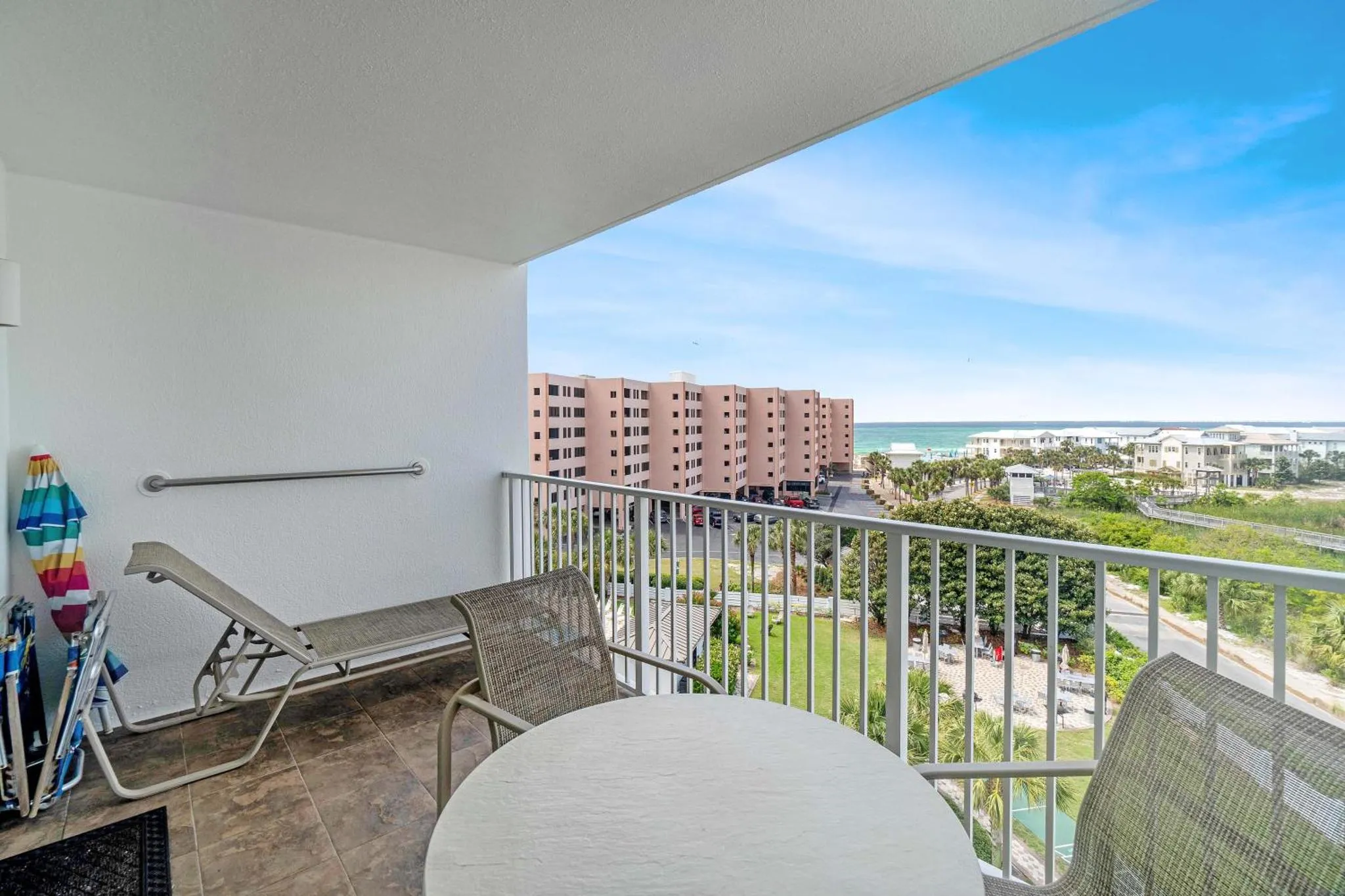 Terrasse avec mobilier d'extérieur et vue sur la mer et les bâtiments environnants.