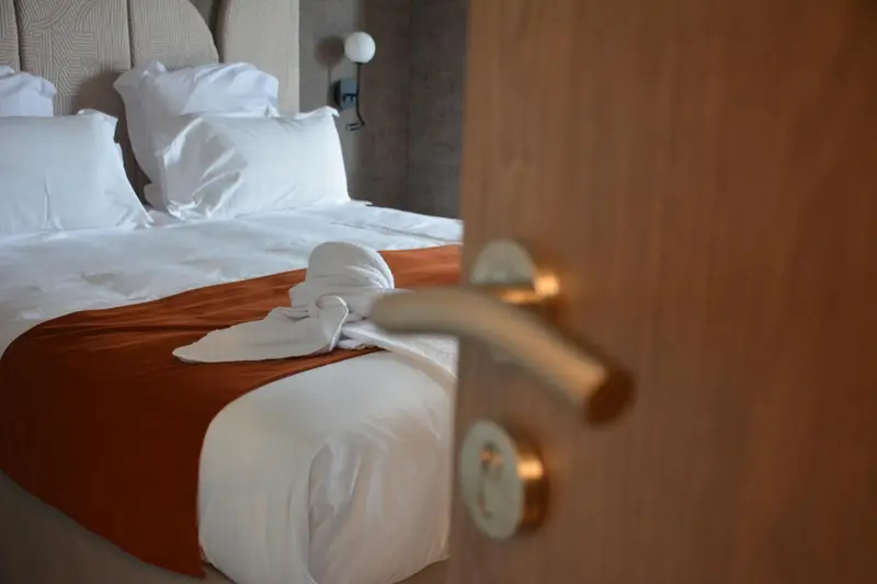 Un lit fait avec soin dans une chambre d'hôtel.