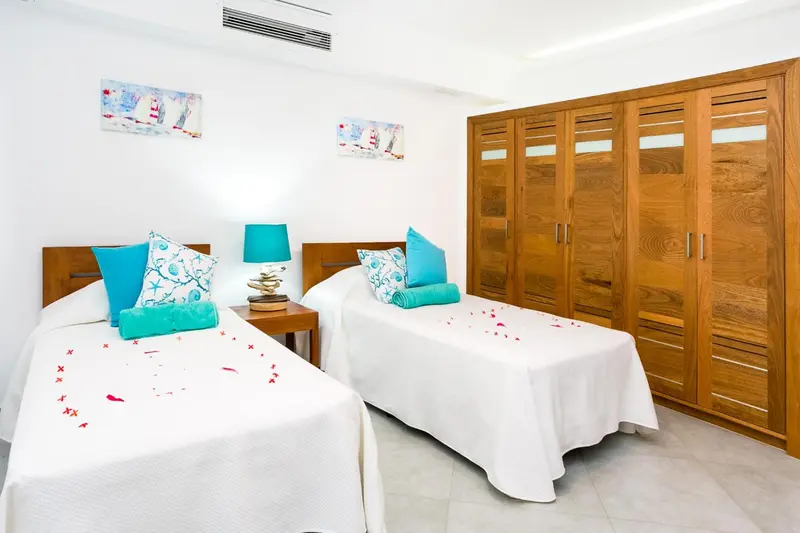 Chambre lumineuse avec deux lits simples et une décoration florale.