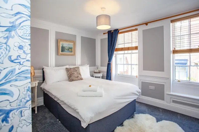 Une chambre lumineuse avec un lit double et un décor sobre.