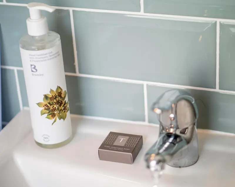 Un distributeur de savon et un savon sont posés sur un lavabo.