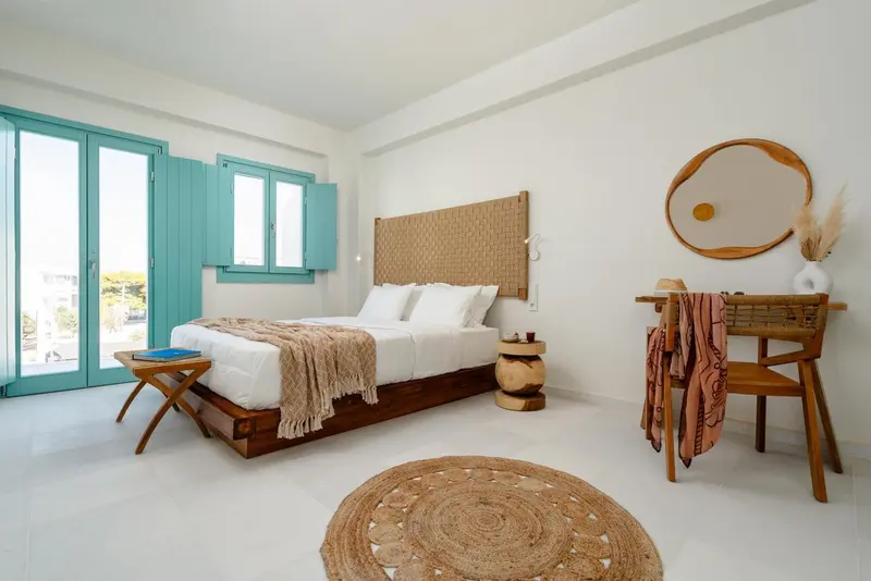 Une chambre lumineuse avec un grand lit et une décoration naturelle.