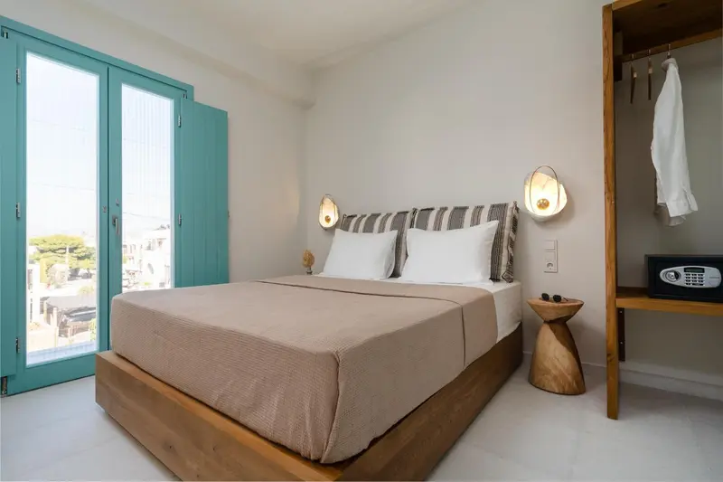 Une chambre lumineuse avec un grand lit et des appliques murales.