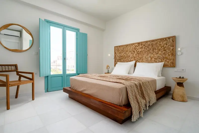 Une chambre lumineuse avec un grand lit et un décor mural en bois.