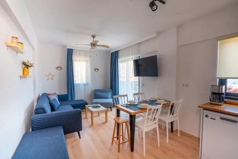 Un salon lumineux avec un coin repas et une kitchenette.