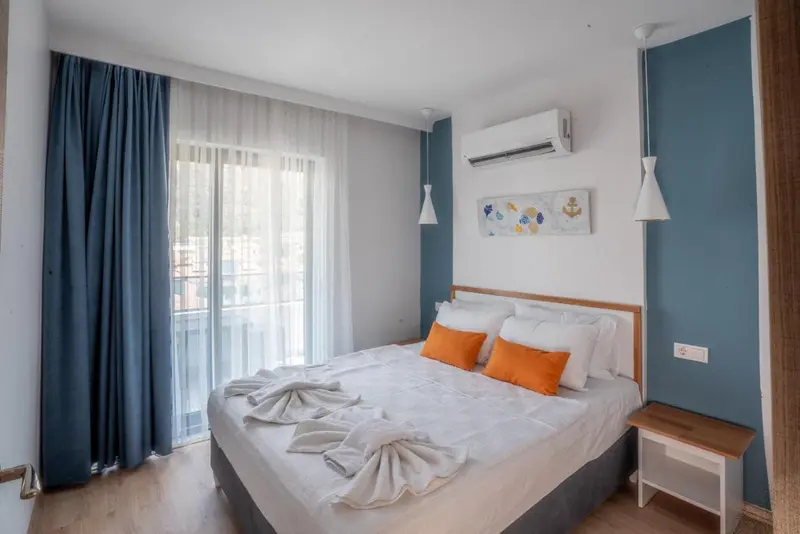 Une chambre lumineuse avec un grand lit et un accès à un balcon.