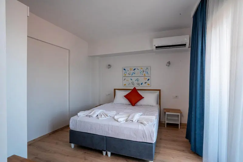 Une chambre lumineuse avec un grand lit et une décoration sobre.