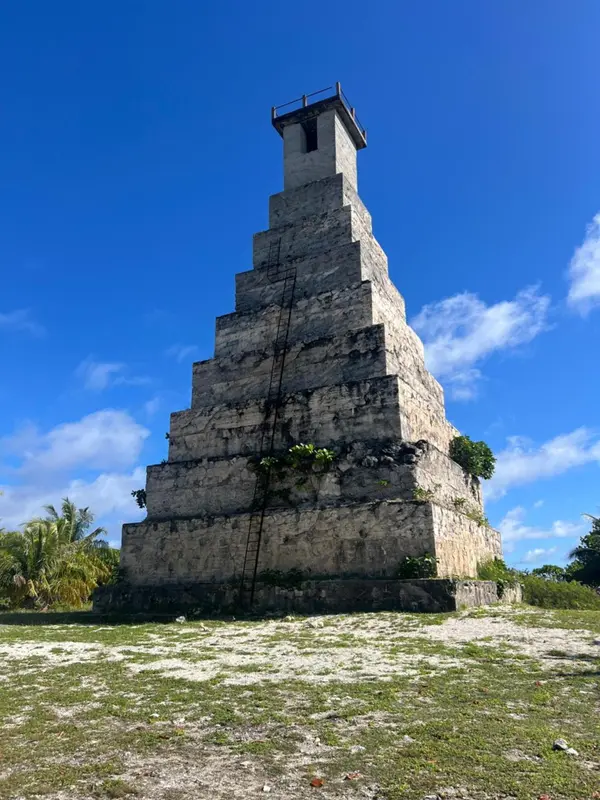 Une structure en pierre à plusieurs niveaux s'élève vers un ciel bleu clair.