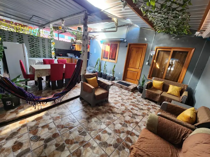 Espace de détente extérieur avec mobilier et végétation luxuriante.
