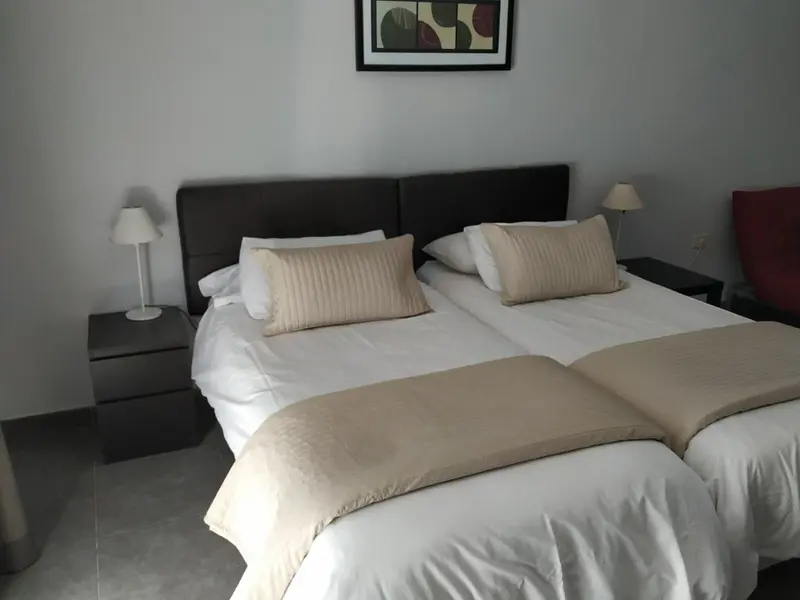 Une chambre avec un grand lit recouvert d'une courtepointe et de coussins.