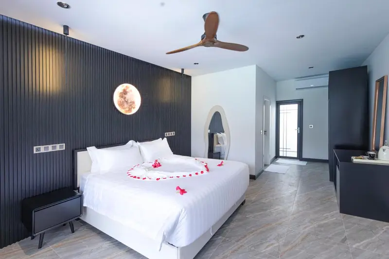Une chambre lumineuse avec un lit recouvert de pétales de fleurs.