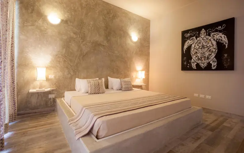 Une chambre lumineuse avec un grand lit et une décoration murale marine.