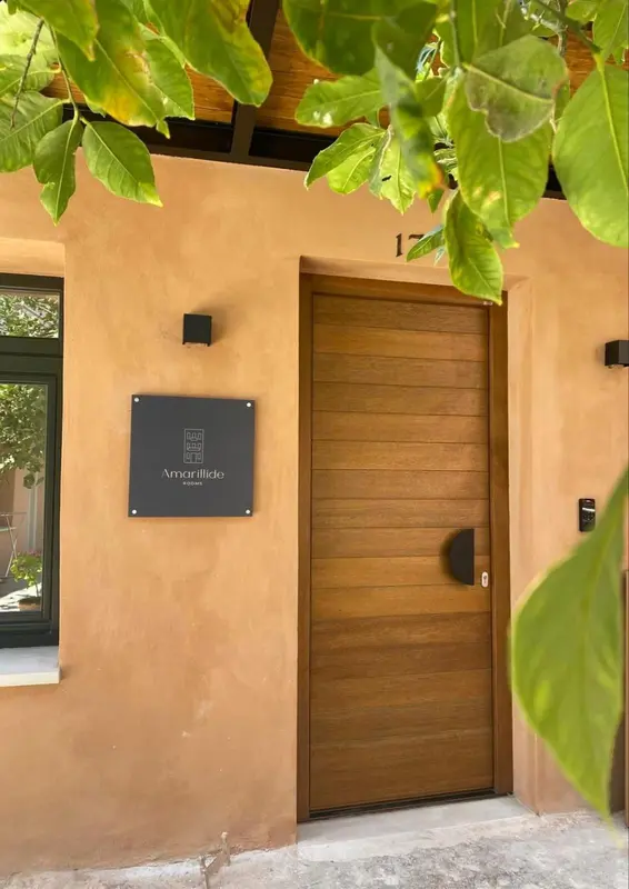 Une porte en bois sombre sur un mur beige.