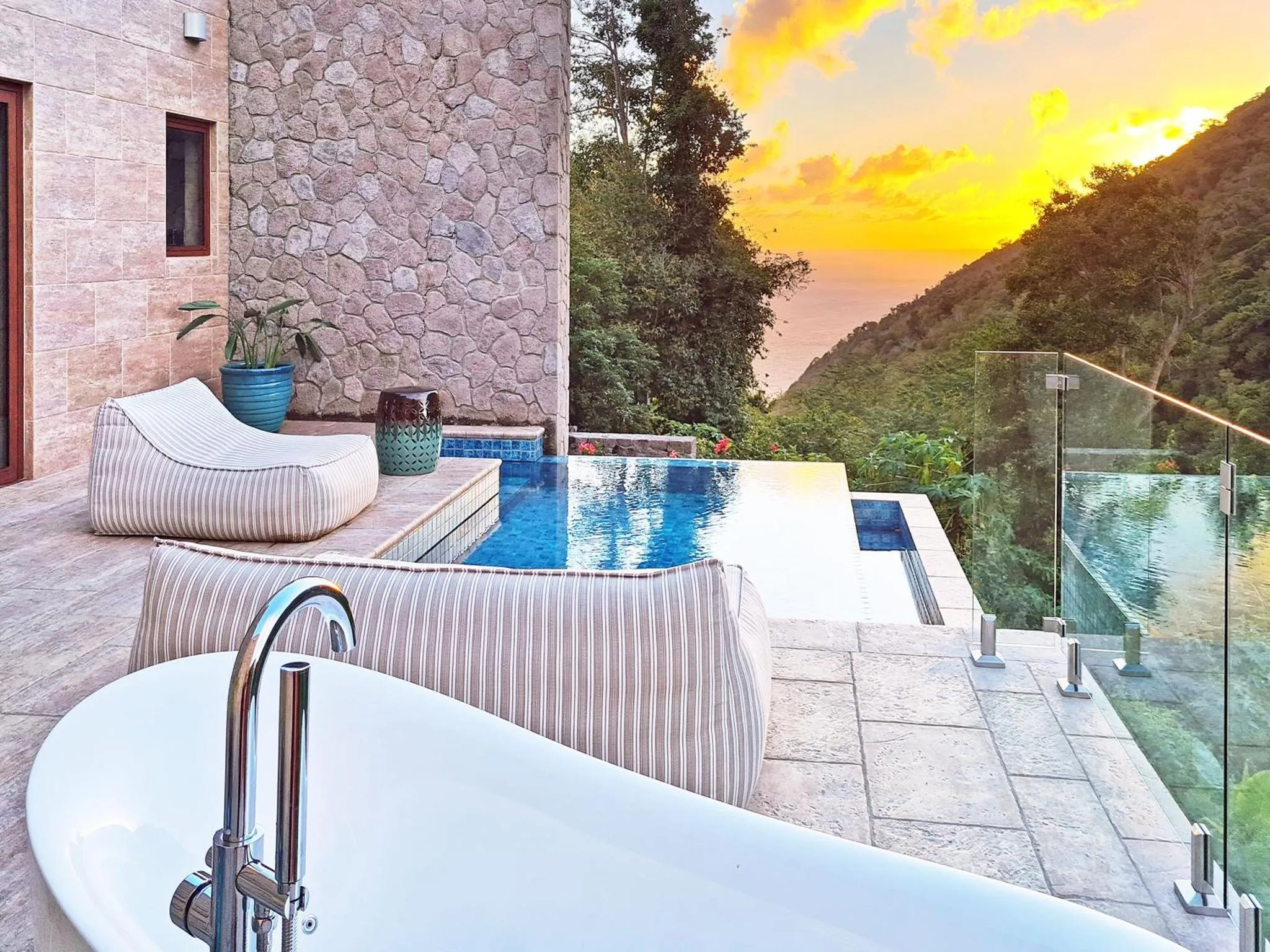 Terrasse avec jacuzzi et piscine à débordement offrant une vue sur la mer.