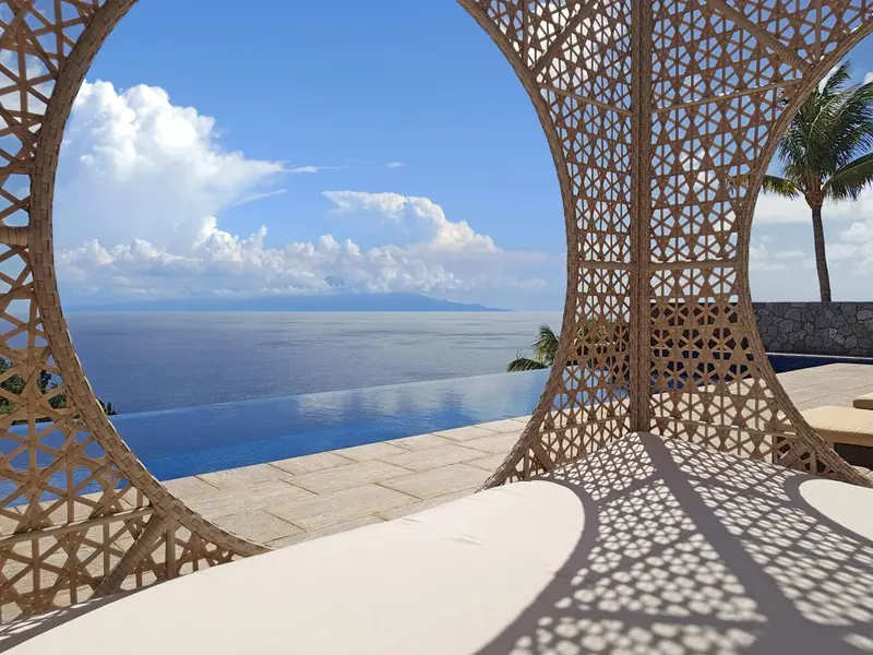 Vue sur l'océan bleu depuis une terrasse ombragée.