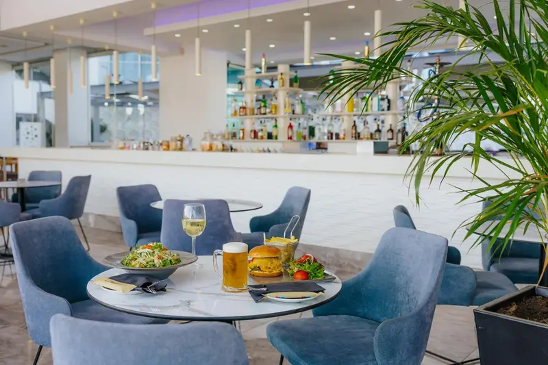 Une table est dressée avec des plats et des boissons dans un espace lumineux.