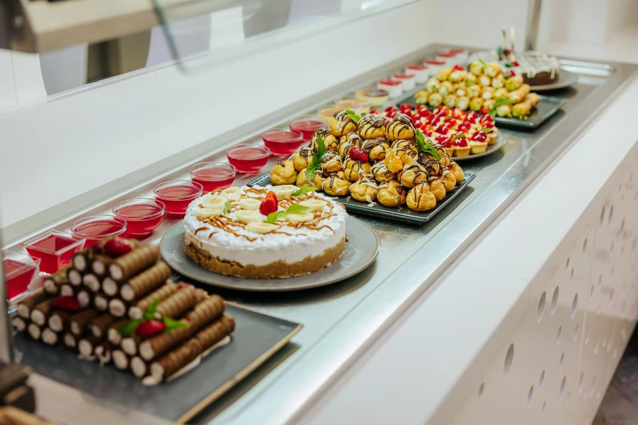 Un buffet propose une variété de pâtisseries et de desserts colorés.