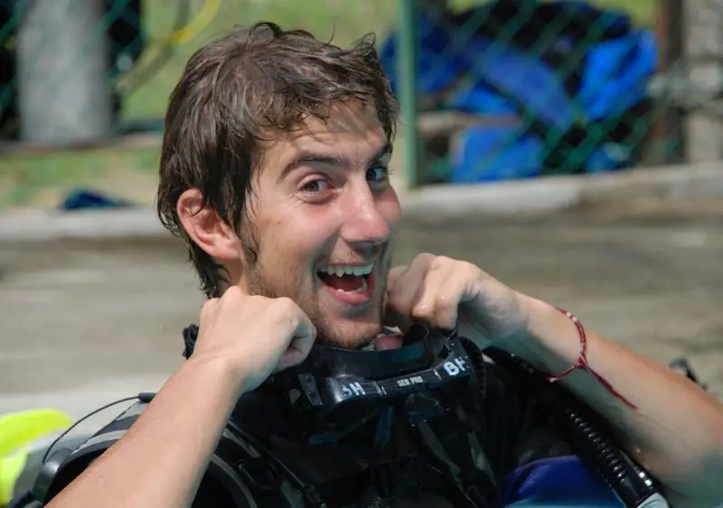 Un homme souriant ajuste son gilet stabilisateur.