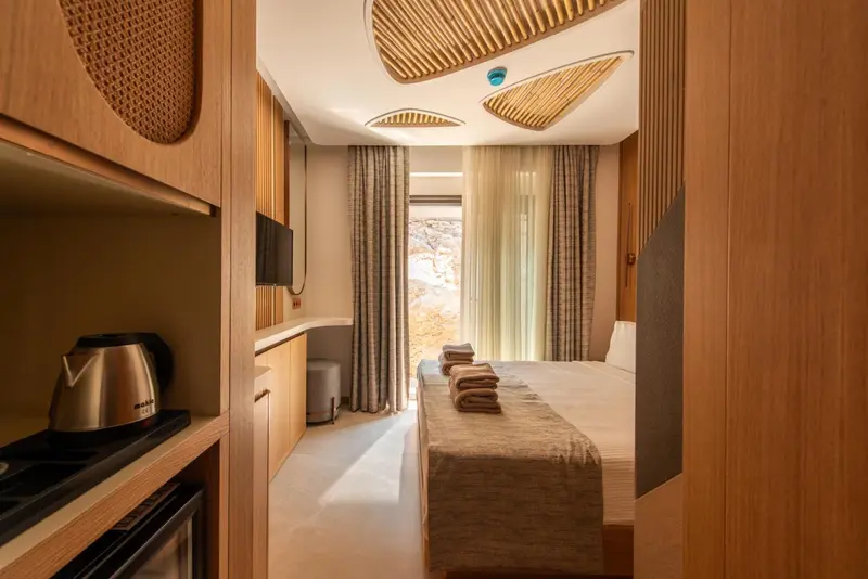 Une chambre lumineuse avec un lit fait et une vue sur l'extérieur.